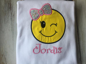 Emoji bow wink face shirt or onesie.
